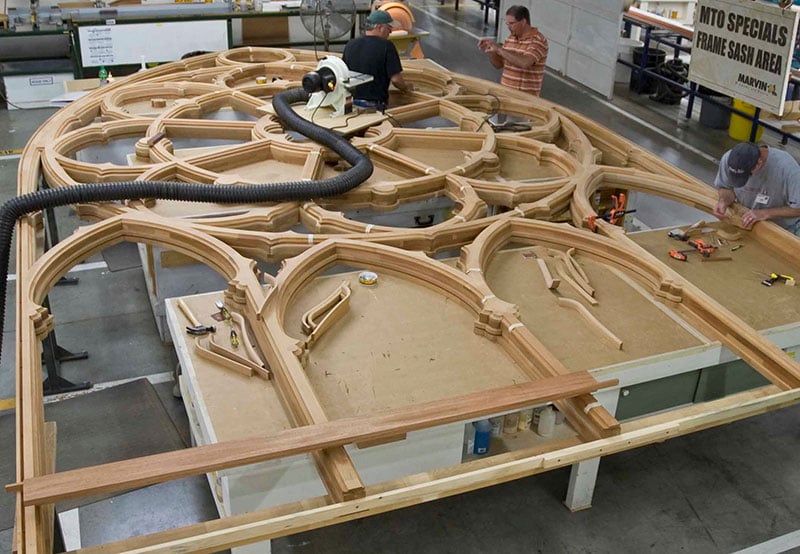 A large, ornate window being made at a Marvin windows and doors factory.